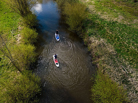 Luftaufnahme von zwei Personen beim Stand-Up-Paddling auf einem Fluss