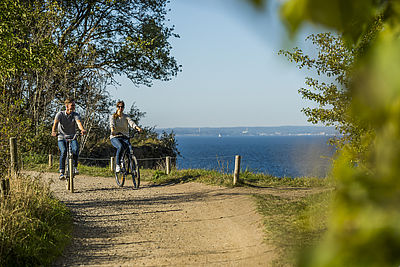 Paar fährt Fahrrad an Küste