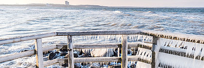Eiszapfen am Holzgeländer an der Ostsee