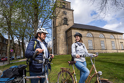 Radfahrende vor einer Kirche