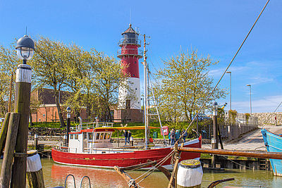 Büsumer Hafen mit Kutter und dem Leuchtturm im Hintergrund