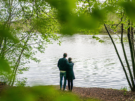 Paar blickt beim Spaziergang auf einen See