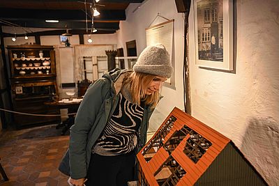 Eine junge Frau schaut sich die Ausstellung im Museum Segeberger Bürgerhaus an.