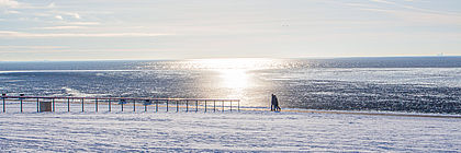 Menschen auf dem verschneiten Deich - zum Artikel 'Gesundheit! Winterurlaub in Büsum an der Nordsee '