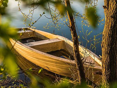 Ein Holzboot am Ufer eines Sees