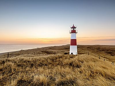 Rot-weiß gestreifter Leuchtturm vor dem Sonnenuntergang an der Nordsee Schleswig-Holstein 
