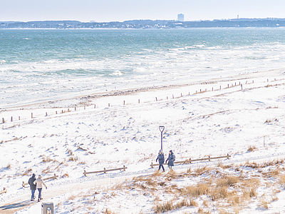 Spazierende auf der verschneiten Promenade an der Ostsee