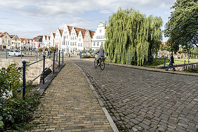 Eine Radfahrerin auf der Grachtenbrücke in Friedrichstadt.